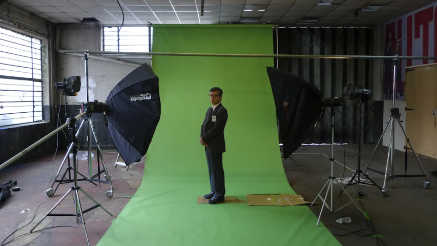there is a man standing in front of a green screen