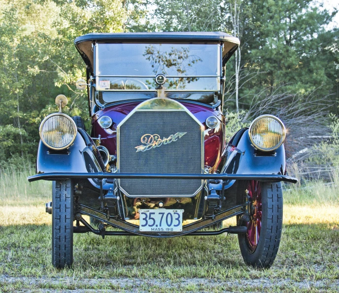 an old fashion car is parked in the grass