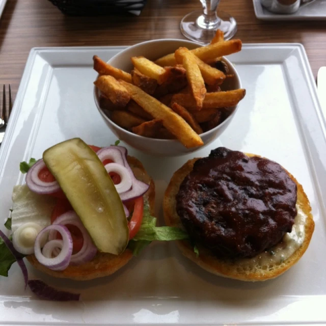 a grilled sandwich with pickle and fries on a tray