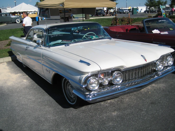 old cars are parked along the curb on a sunny day