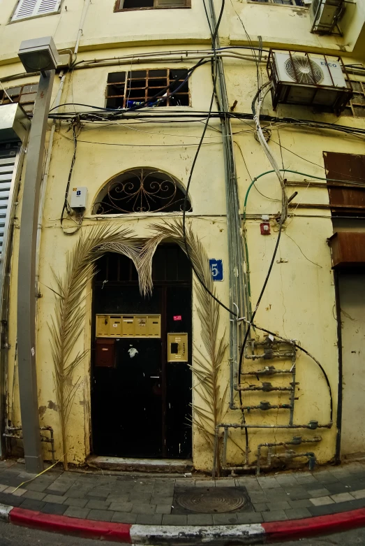 a yellow building with many cables above and down