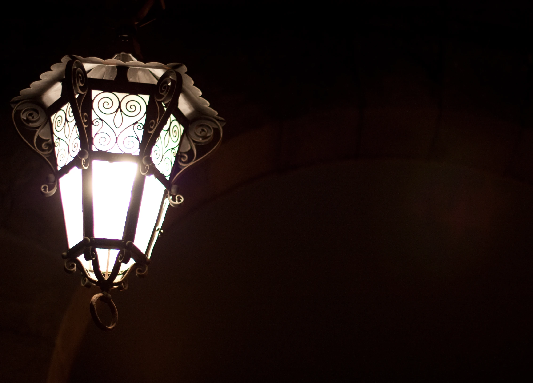 an old - fashioned street lamp lit in the dark