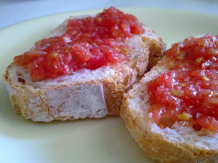 two small bread halves with tomatoes and sauce on them