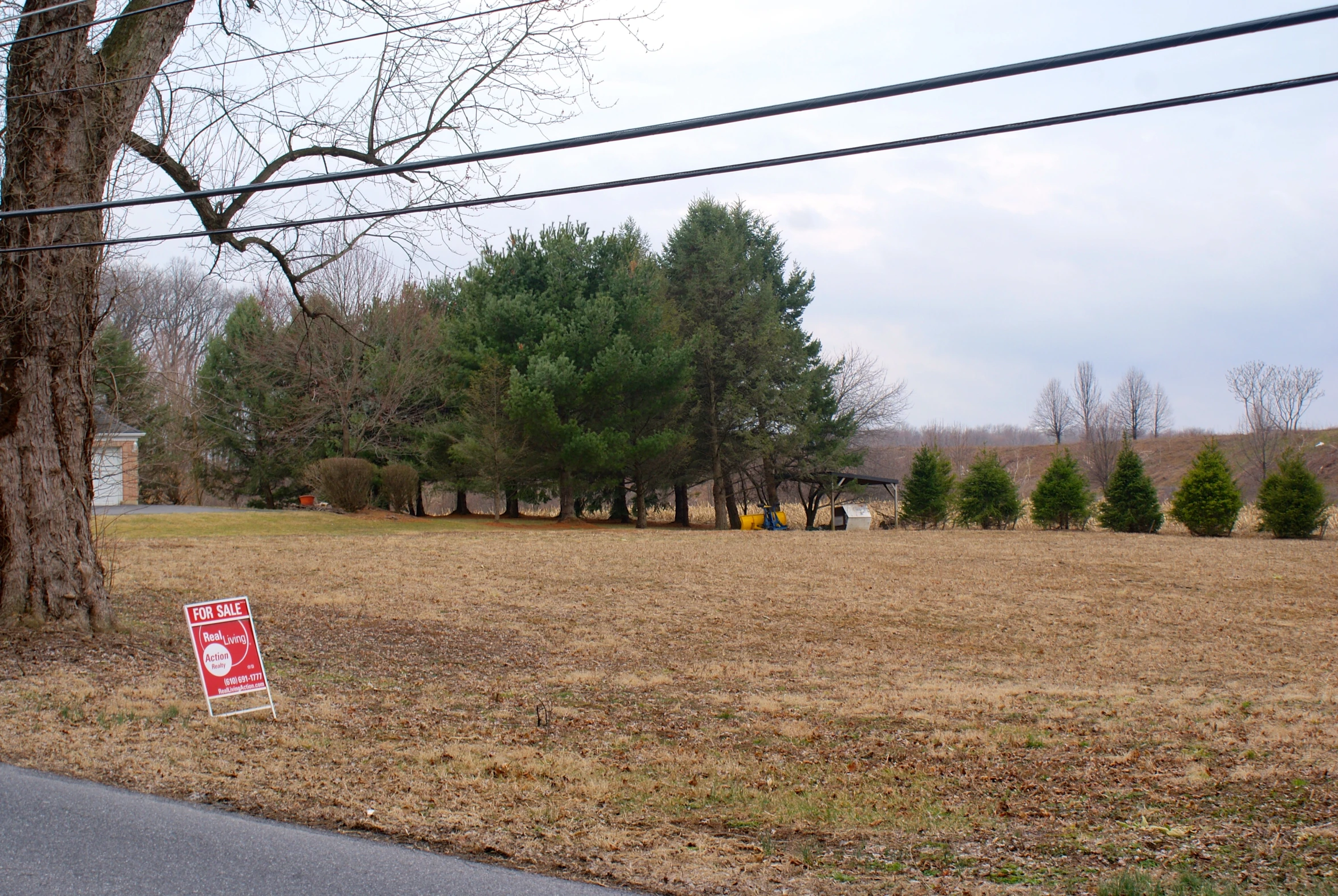 a red stop sign in the middle of a grass field with power lines overhead