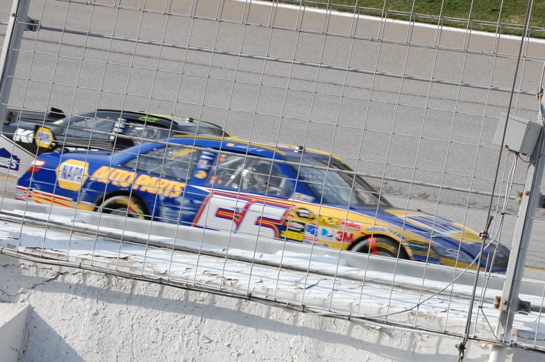 a car being driven by two cars behind a fence