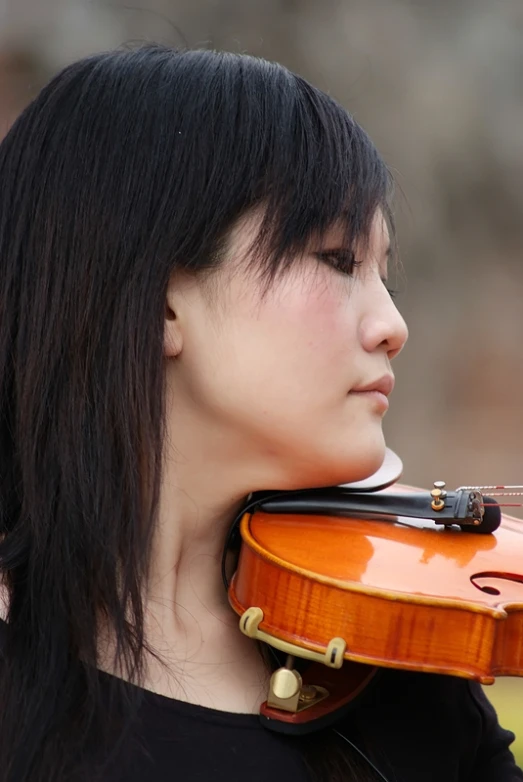 the woman with long black hair is playing her violin