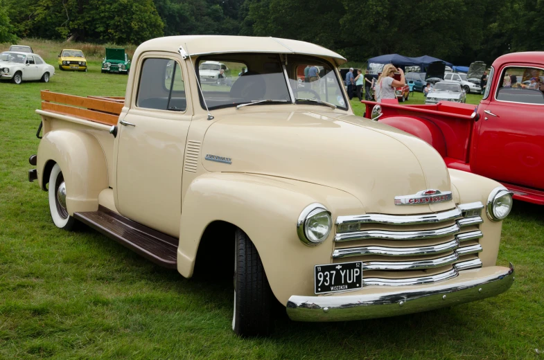 old style truck at a car show near other cars