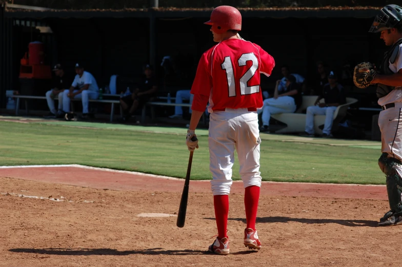 a baseball player holding a bat near another player
