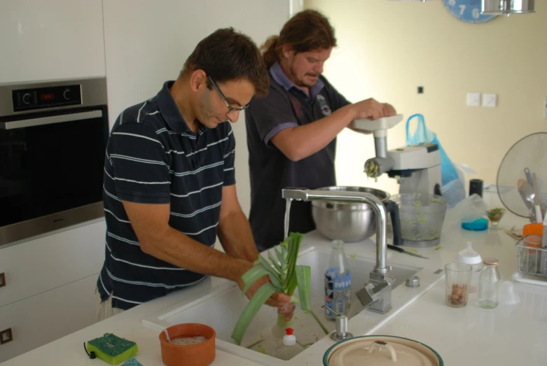 two men are preparing vegetables and some type of substance