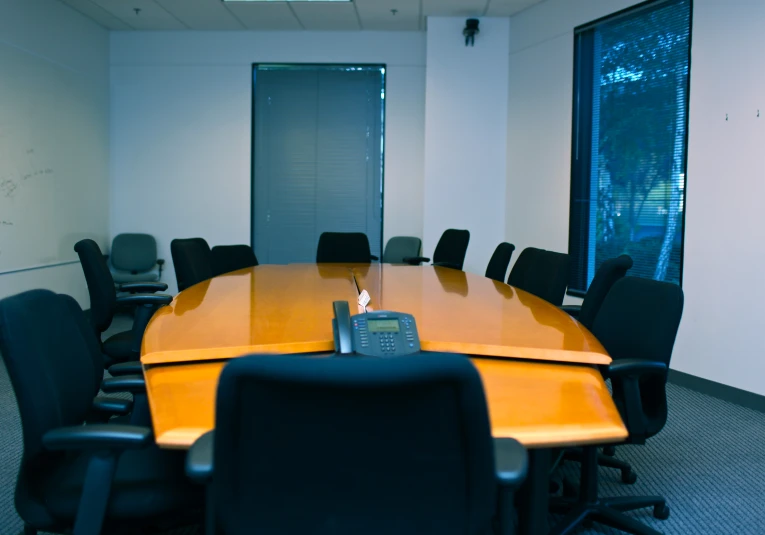 an empty conference room with a phone on the table