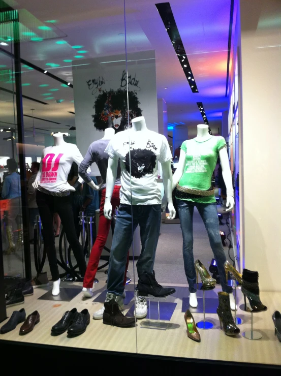 a display case of men's shoes and t - shirts in a retail window