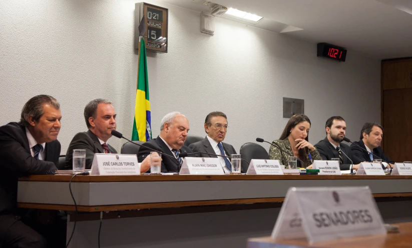 five people sitting at a table with papers