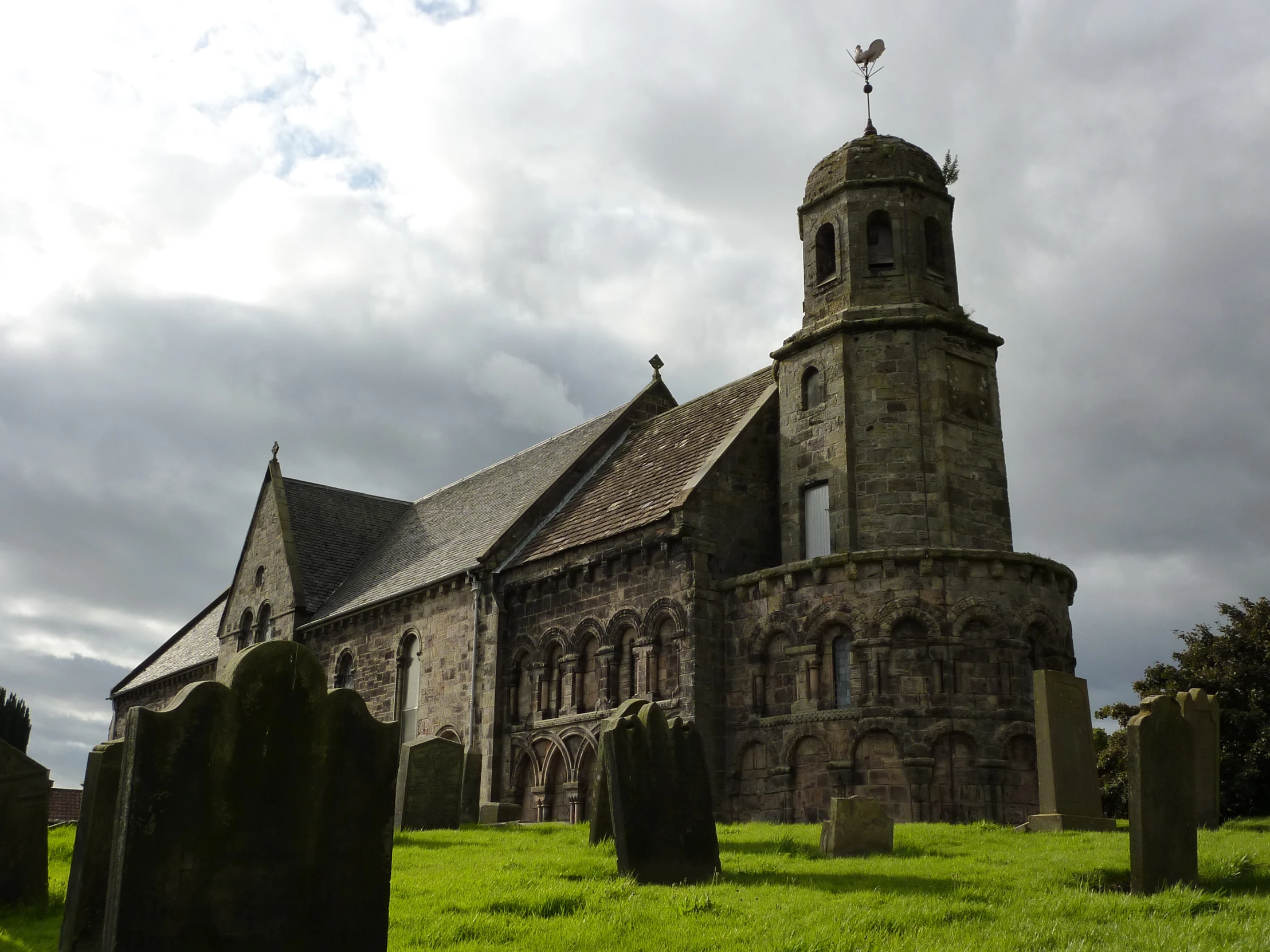 a large church sits in the middle of a green field