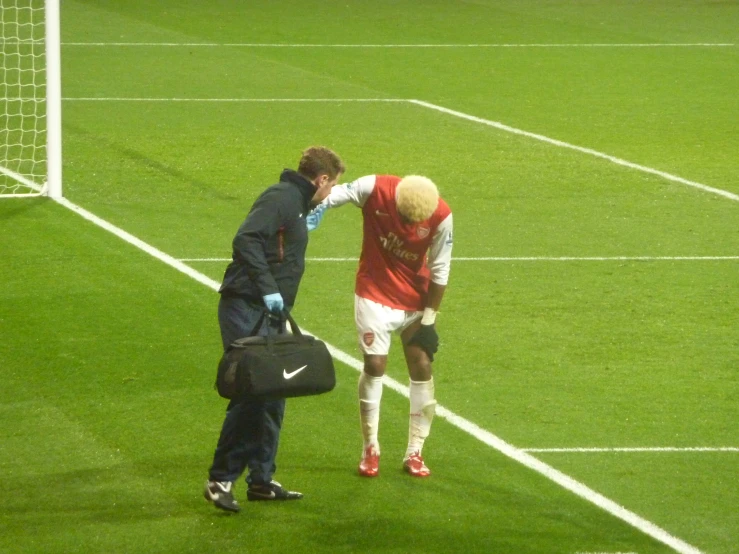 two soccer players touching each other with hands