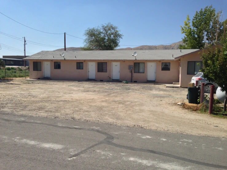 a small pink colored motel sits near the road