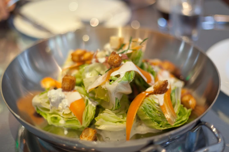 lettuce in a bowl with bacon and a dressing