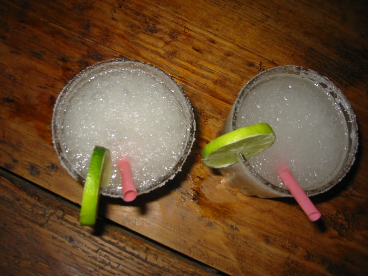 two glasses of ice with sugar and lime on them