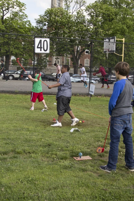 two people standing on the grass playing with a child