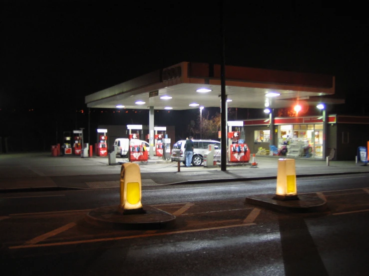 an empty gas station with a few trucks in it