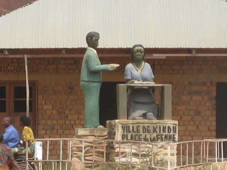 two statues of people who are pointing their hands at soing