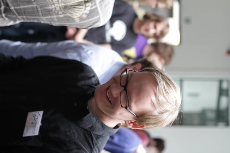 a man smiling next to some people standing around