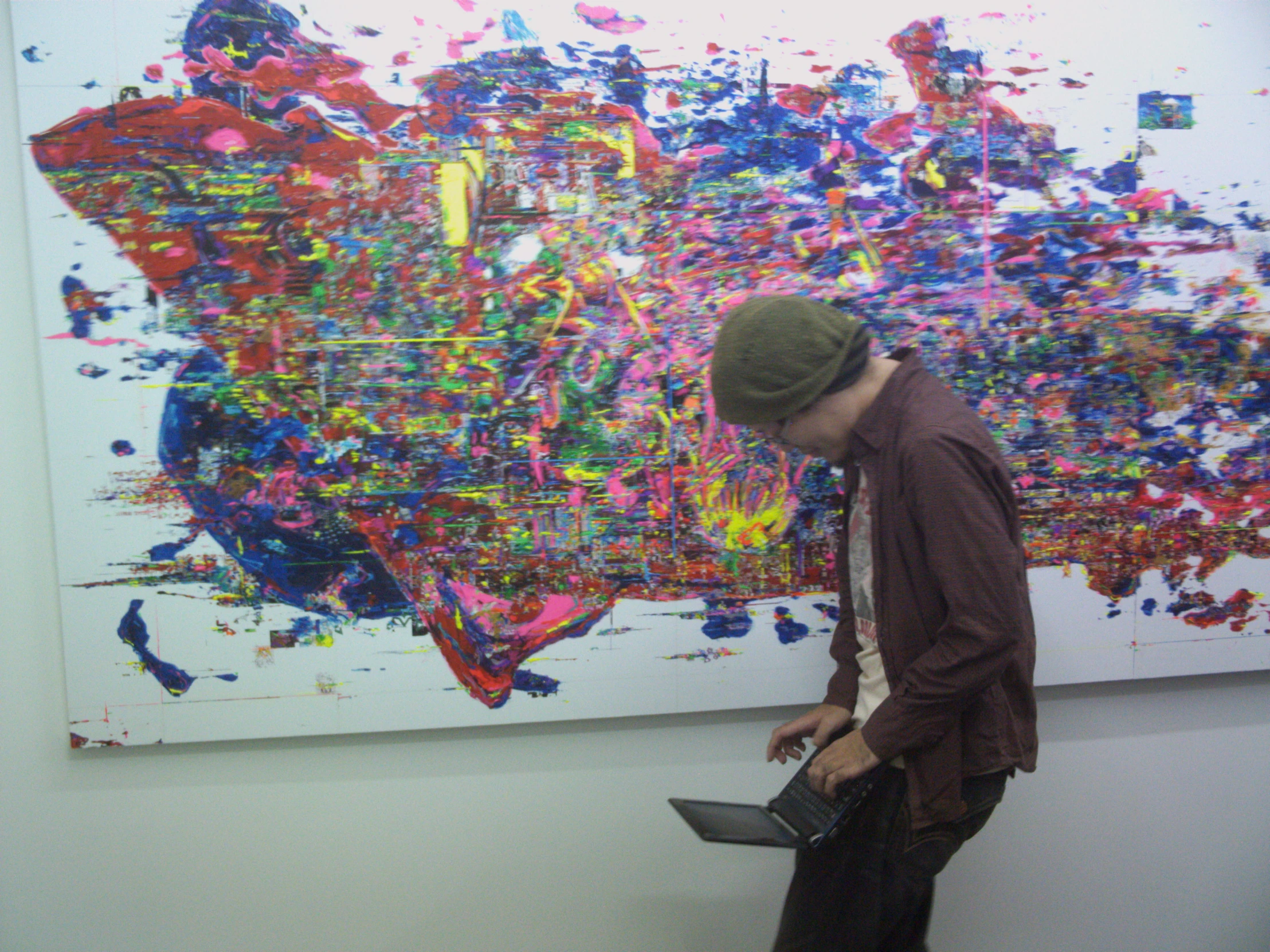 a person walking near a large painting on the wall