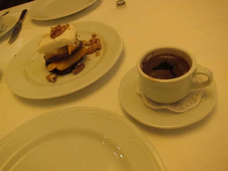a table with plates of dessert, mug and fork