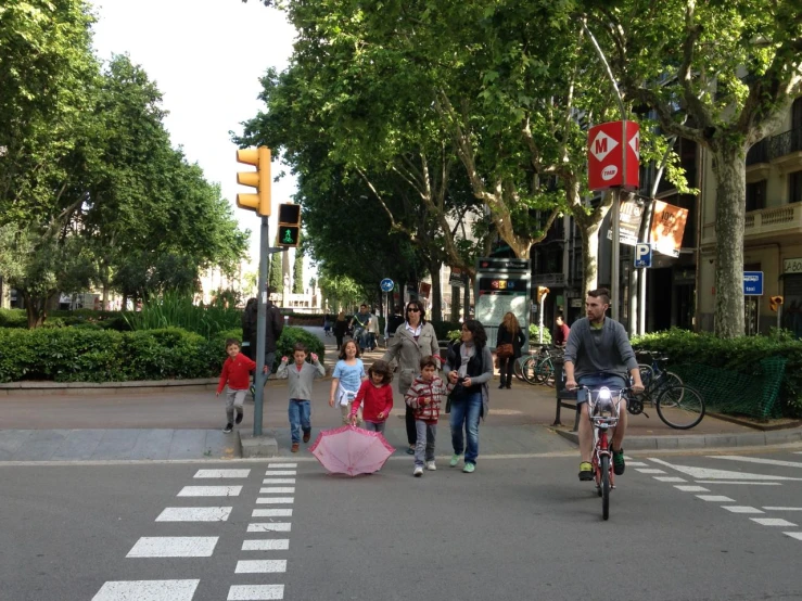 children with large round backpacks ride their bikes in the road