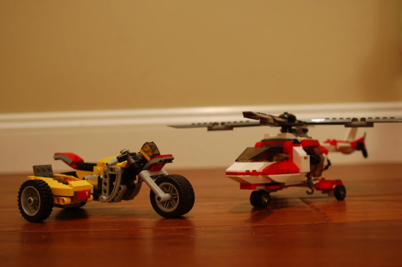 two toy vehicles are parked on a wood floor