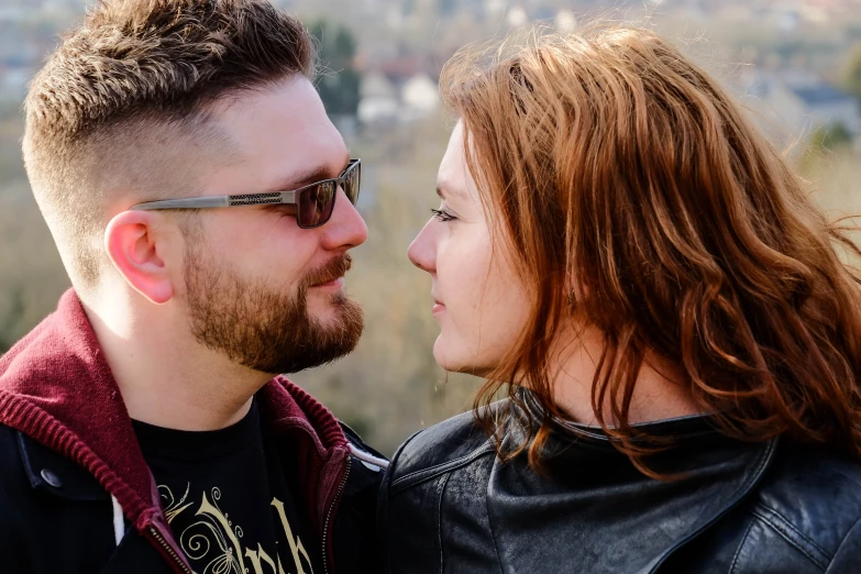 a young man kissing a red headed woman