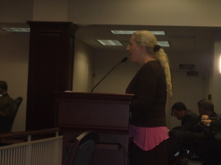 a woman standing in front of a microphone at a podium