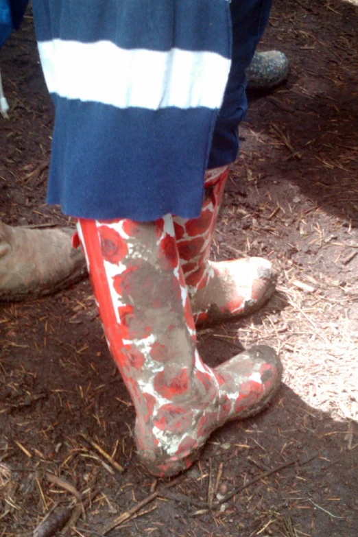 someone wearing bright pink rain boots walking on a path