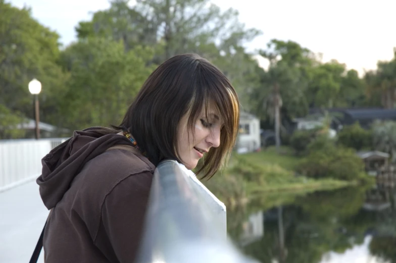 the  holds on to her skateboard while staring at the water