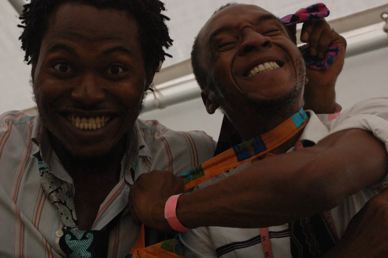 two men with ties are smiling for the camera