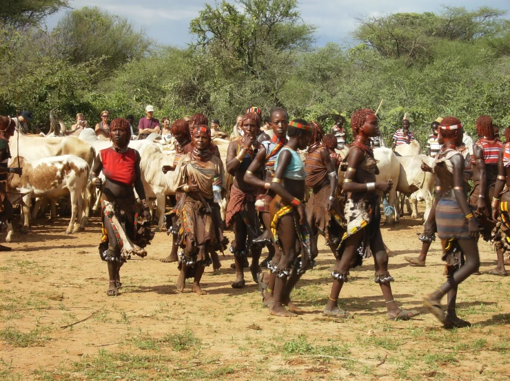 many people are gathered around and walking in the dirt