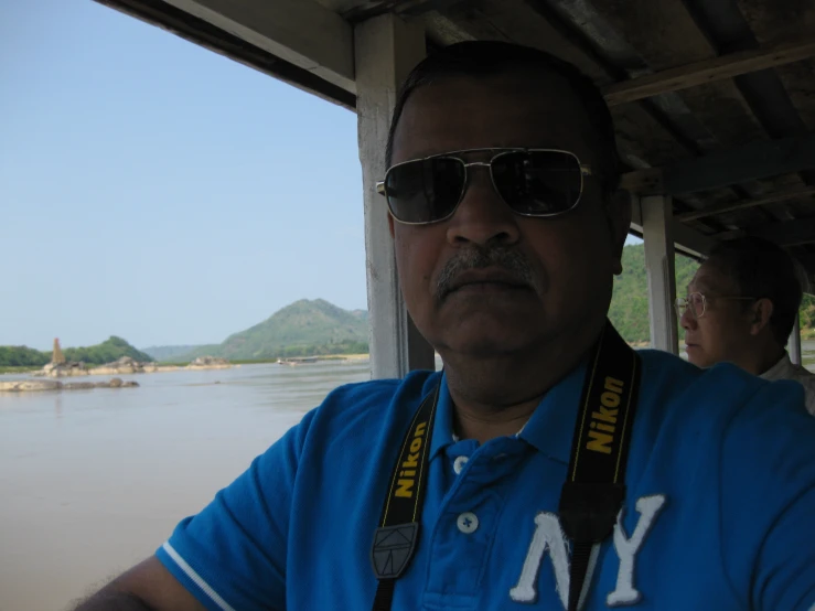 the man is wearing sunglasses while looking at the water