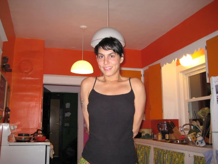 girl wearing an helmet standing in the kitchen