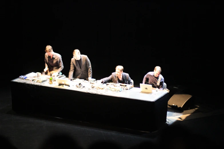 people standing in line around a table filled with food