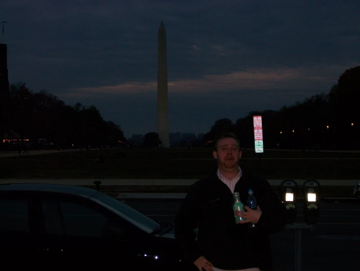 a man is holding two drinks next to the lincoln monument