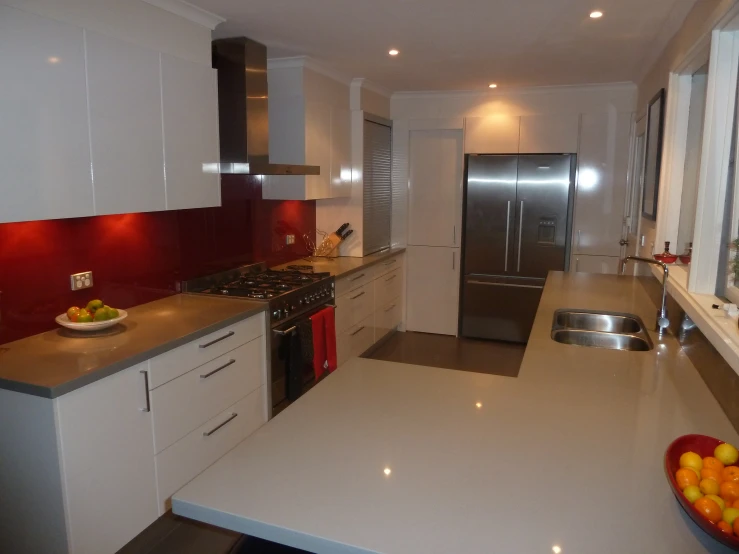 a white kitchen with lots of counter space and stainless steel appliances