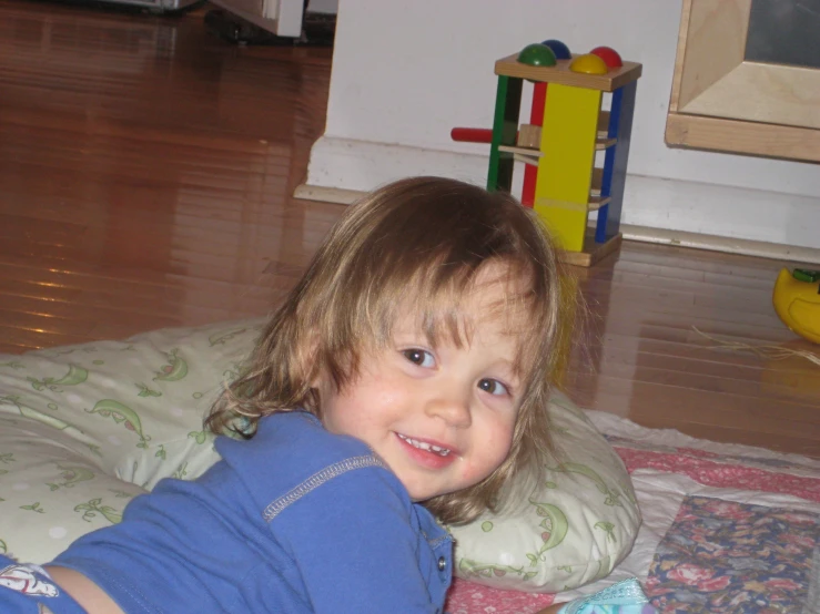 a little girl lying on the floor smiling