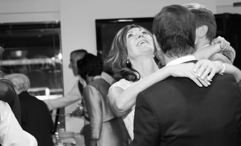 the woman is hugging her groom while dancing
