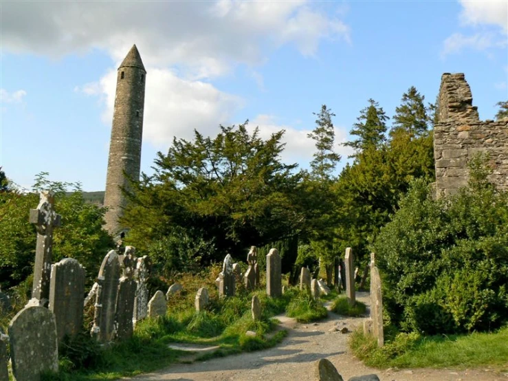 a long old walking path lined with ancient rocks and a large stone tower