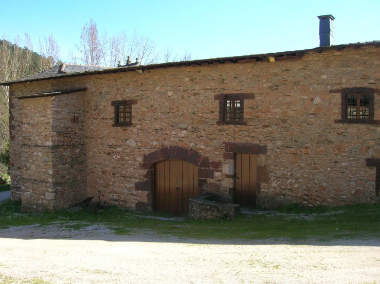 an old house with doors on two sides and windows above the doorways