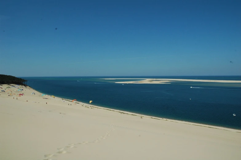 people and cars are on a beach next to the ocean