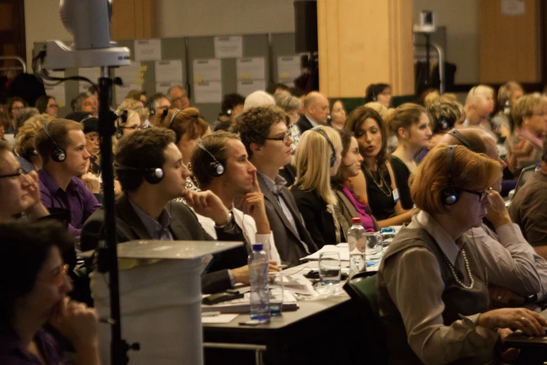 a group of people sitting in rows with headsets on