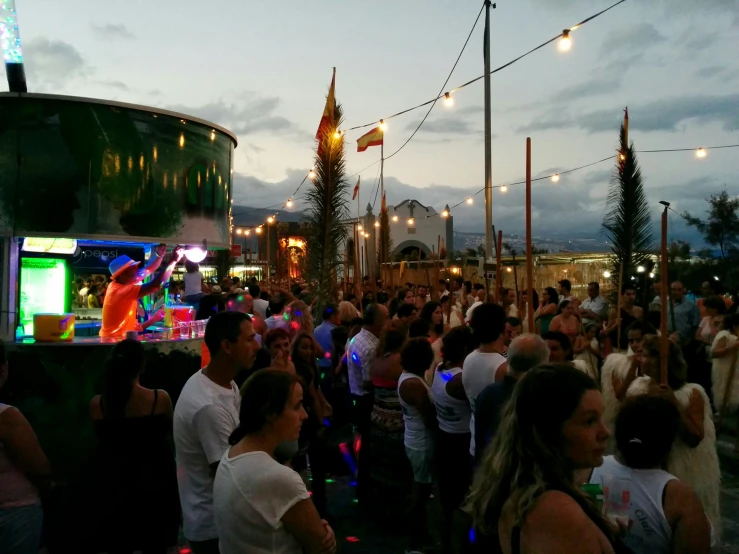 people dance together in a crowd at night