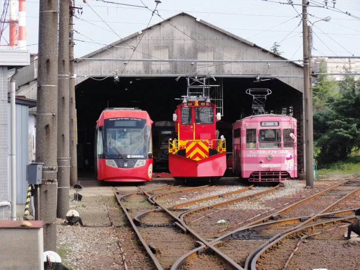 three trains are parked side by side in a station