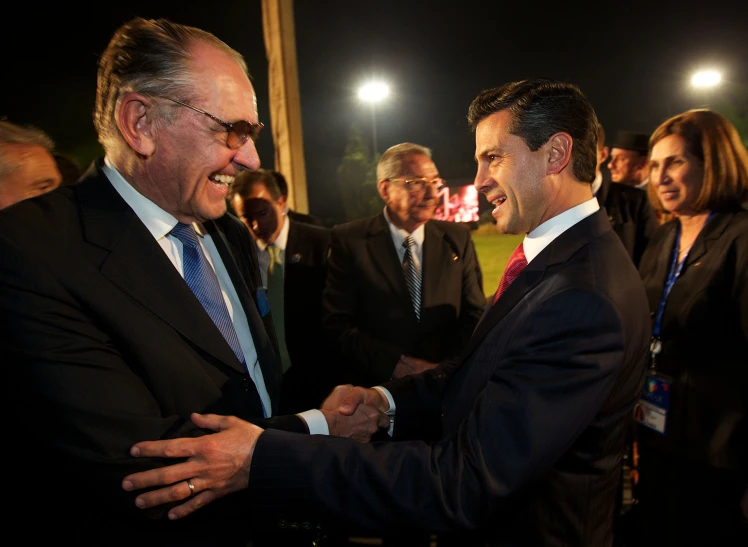 two men standing next to each other shaking hands