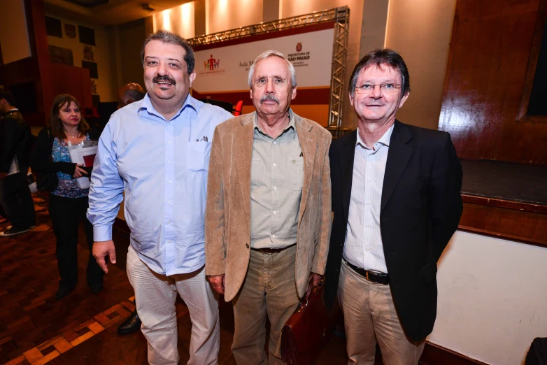 three men and one woman standing together at a party